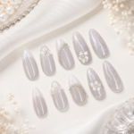 White Pearl Floral handmade press-on nails are designed for a soft, elegant salon-quality manicure at home. This set features a glossy white and sheer nude base with delicate 3D floral details, pearl accents, and lace-inspired nail art for a romantic feminine look. Perfect for brides, engagements, weddings, bridal showers, Eid, parties, and elegant everyday wear, these reusable press-on nails give you a polished manicure without a salon visit.